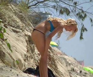 Teenage lengthy legged blond sunbathing in g-string bikini.